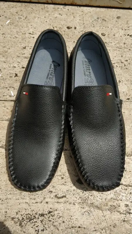 Black leather loafers with red and white side accents.