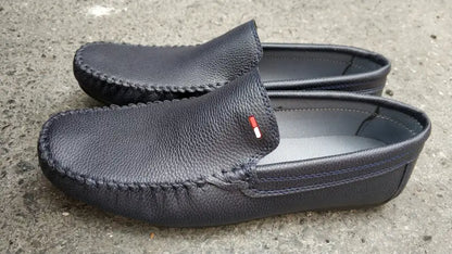 Black leather loafers with a small red and white logo detail.