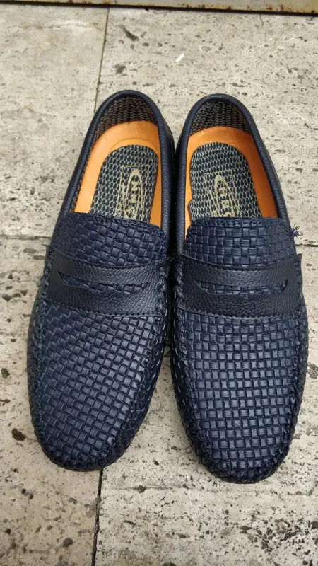 Navy blue woven leather loafers with penny keeper straps.