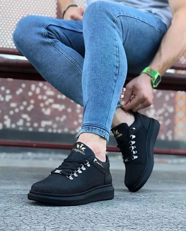 Black Adidas sneakers with white laces and a mesh upper design.